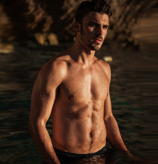 Shirtless athletic man standing in water stock photo